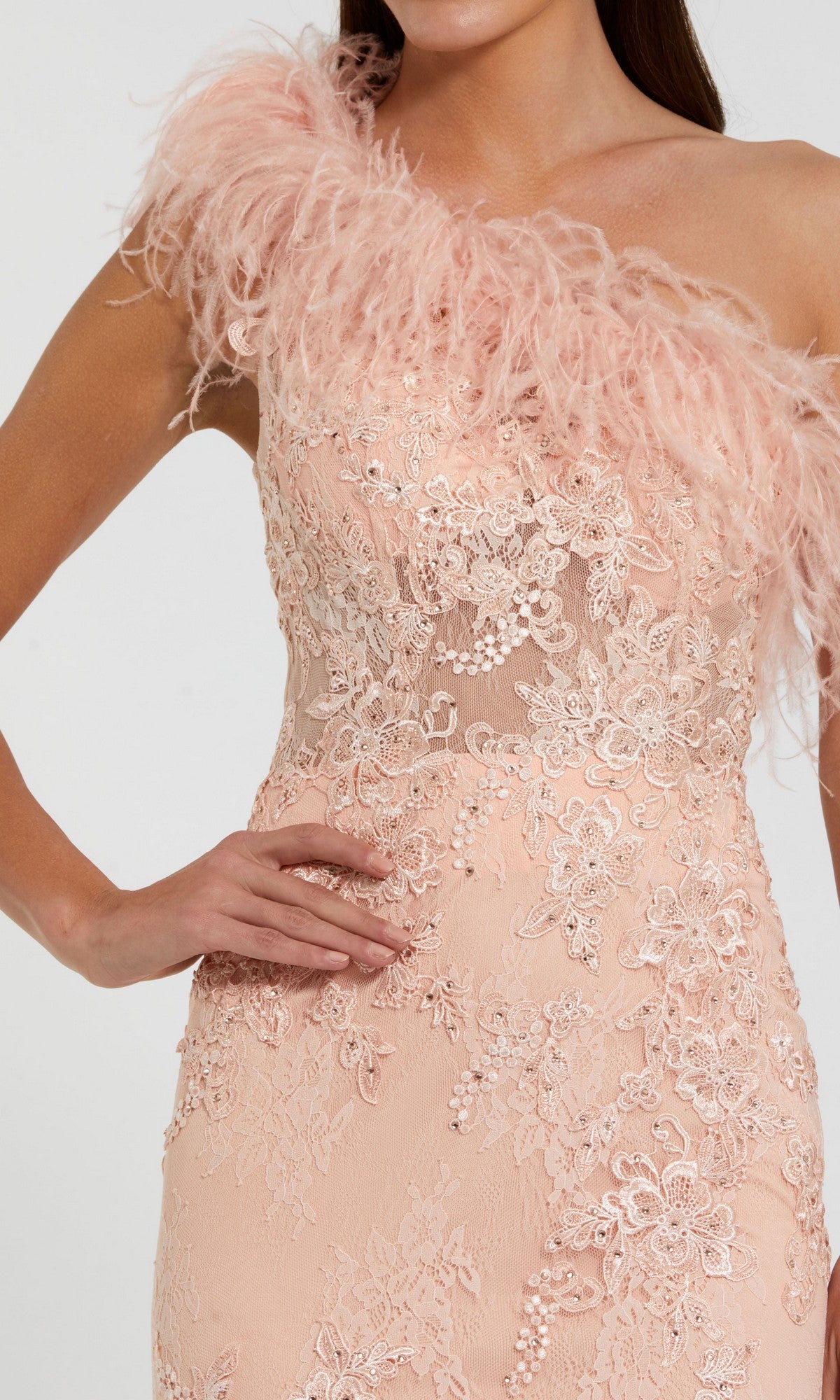 Woman wearing the Mac Duggal 79451 Long Formal Dress in blush pink, featuring a one-shoulder design, embellished mesh, lace embroidery, bead accents, and a feather-trimmed neckline.